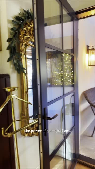 Reel by @nicholnaranjo: Black narrow-profile door with eight glass panes beside a lit porch with a chair.